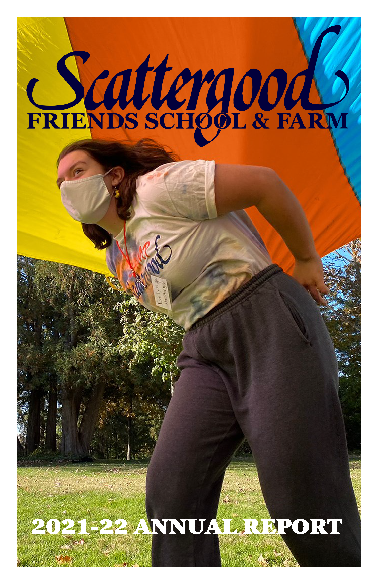 Cover of the 2021-2022 Annual Report. The photo is of a student playing with a colorful parachute during the fall open house.